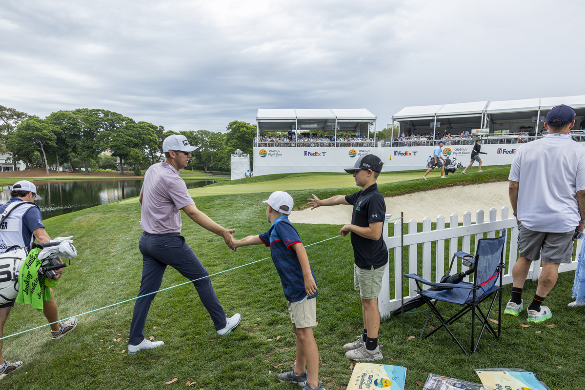 A golfer high fives two boys on the way to the next hole at the ONEflight Myrtle Beach classic.